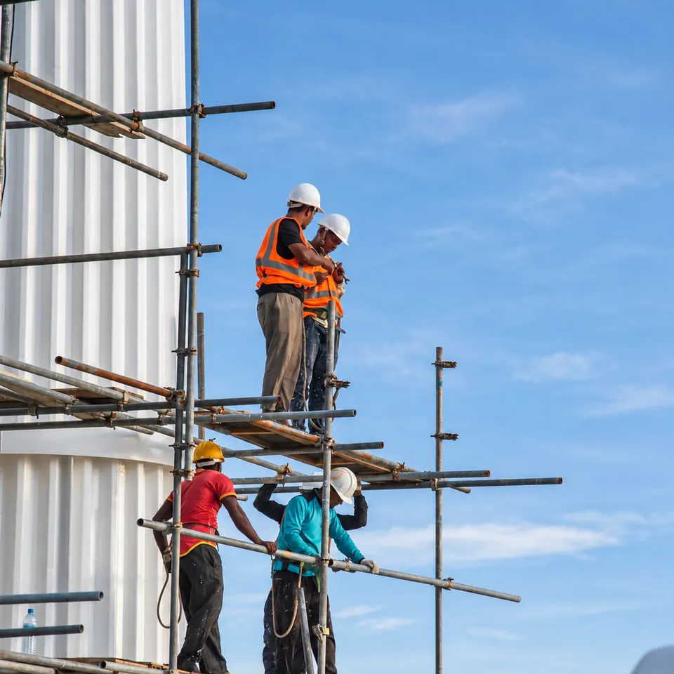 Construction workers on scaffolding beside a building